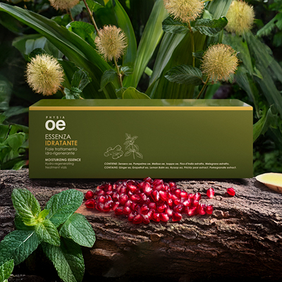 immagine del prodotto fiala essenza ambientata su sfondo con melograno e fiori gialli 